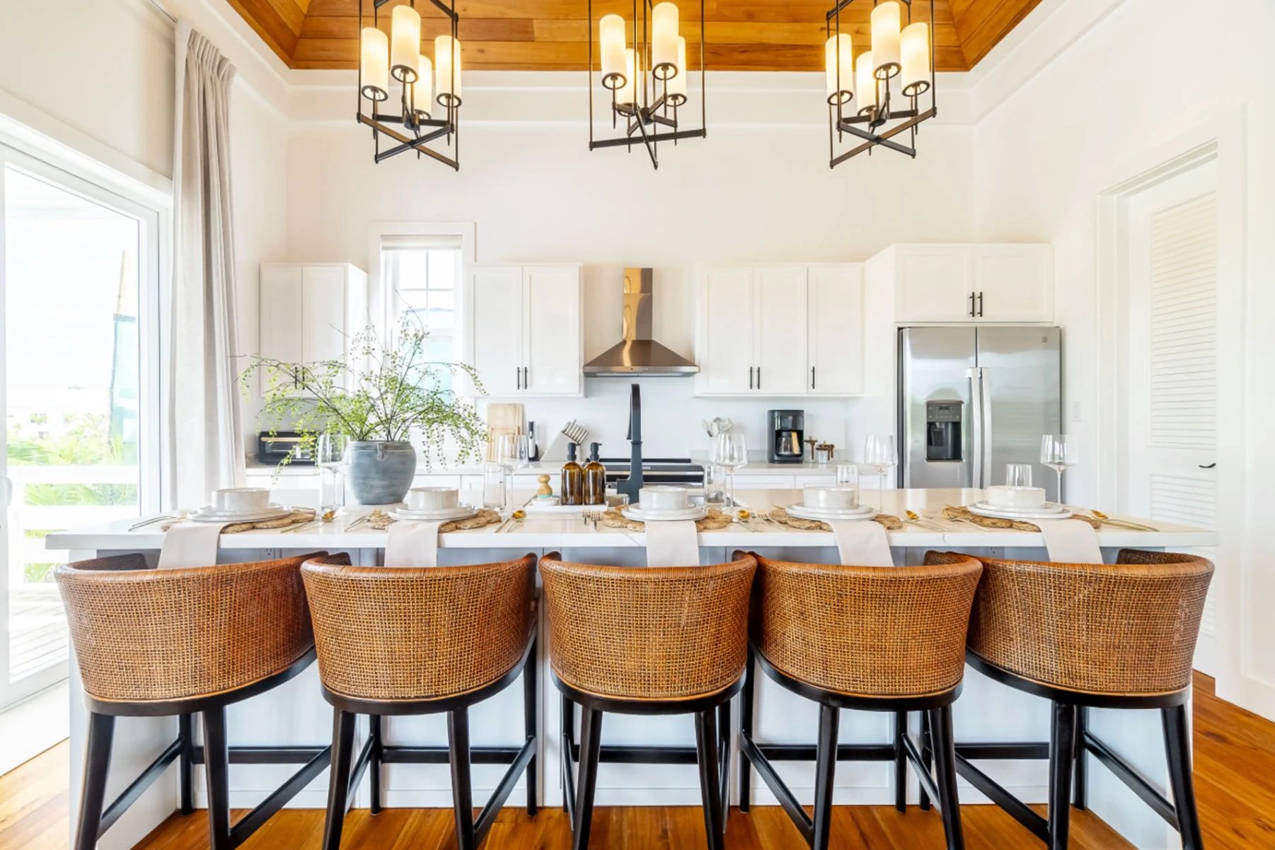 Kitchen island with woven rattan barstools and set place settings