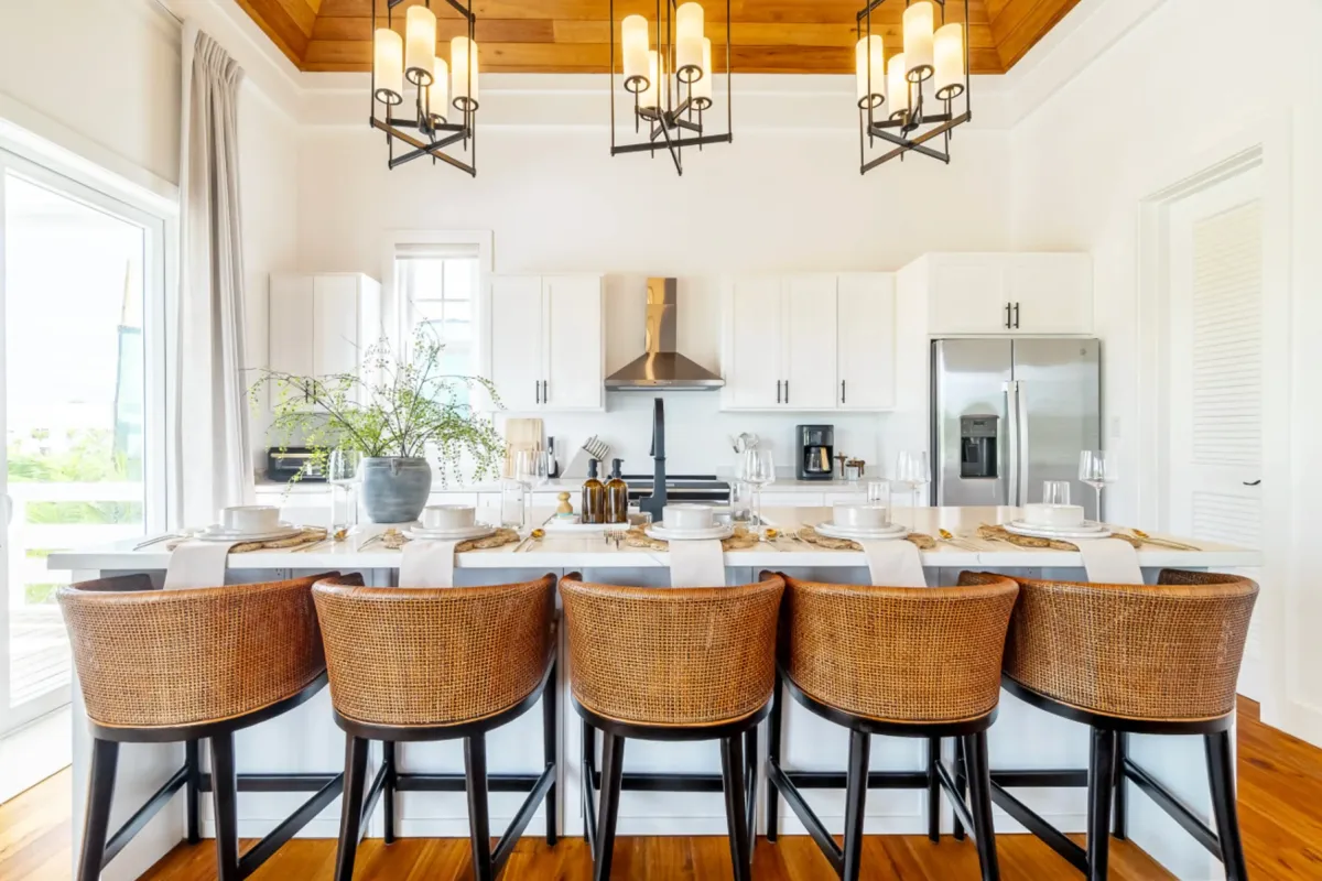 Kitchen island with woven rattan barstools and set place settings