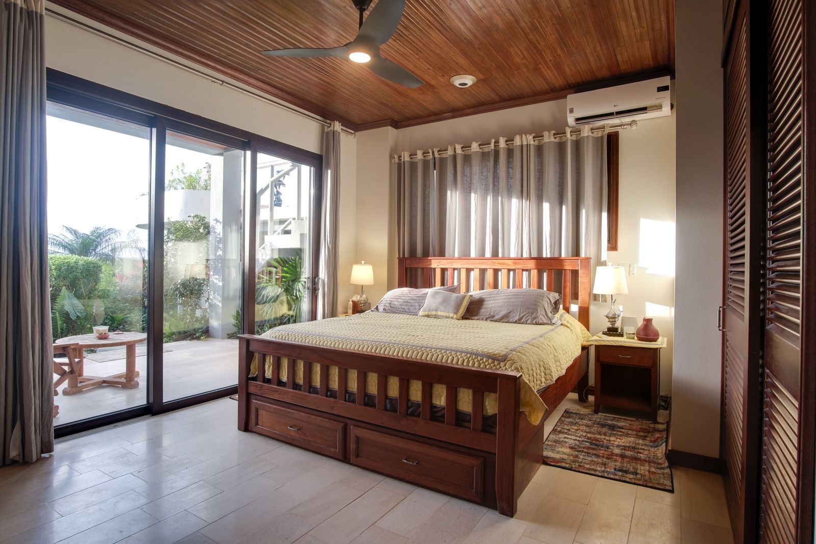Bedroom with wood-slat bed, under-bed drawers, and wood plank ceiling fan