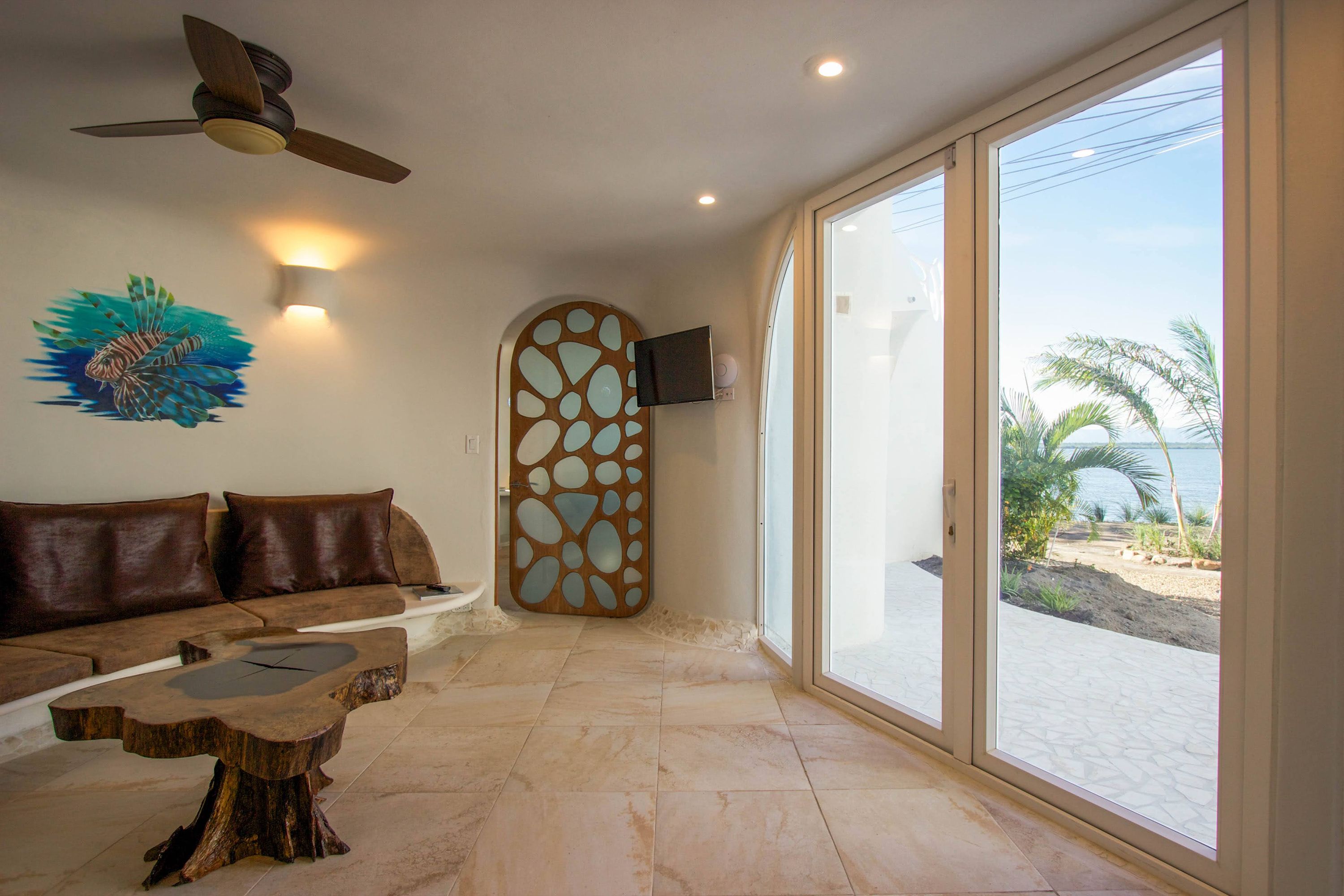 Interior corner with wall-mounted television beside arched window and pebble-pattern wooden panel