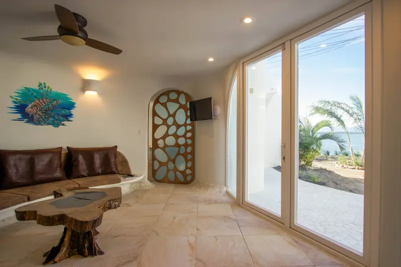 Interior corner with wall-mounted television beside arched window and pebble-pattern wooden panel