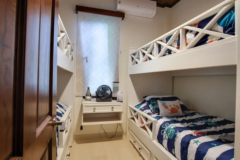 Bedroom with white bunk beds, ocean-themed bedding and a floating nightstand