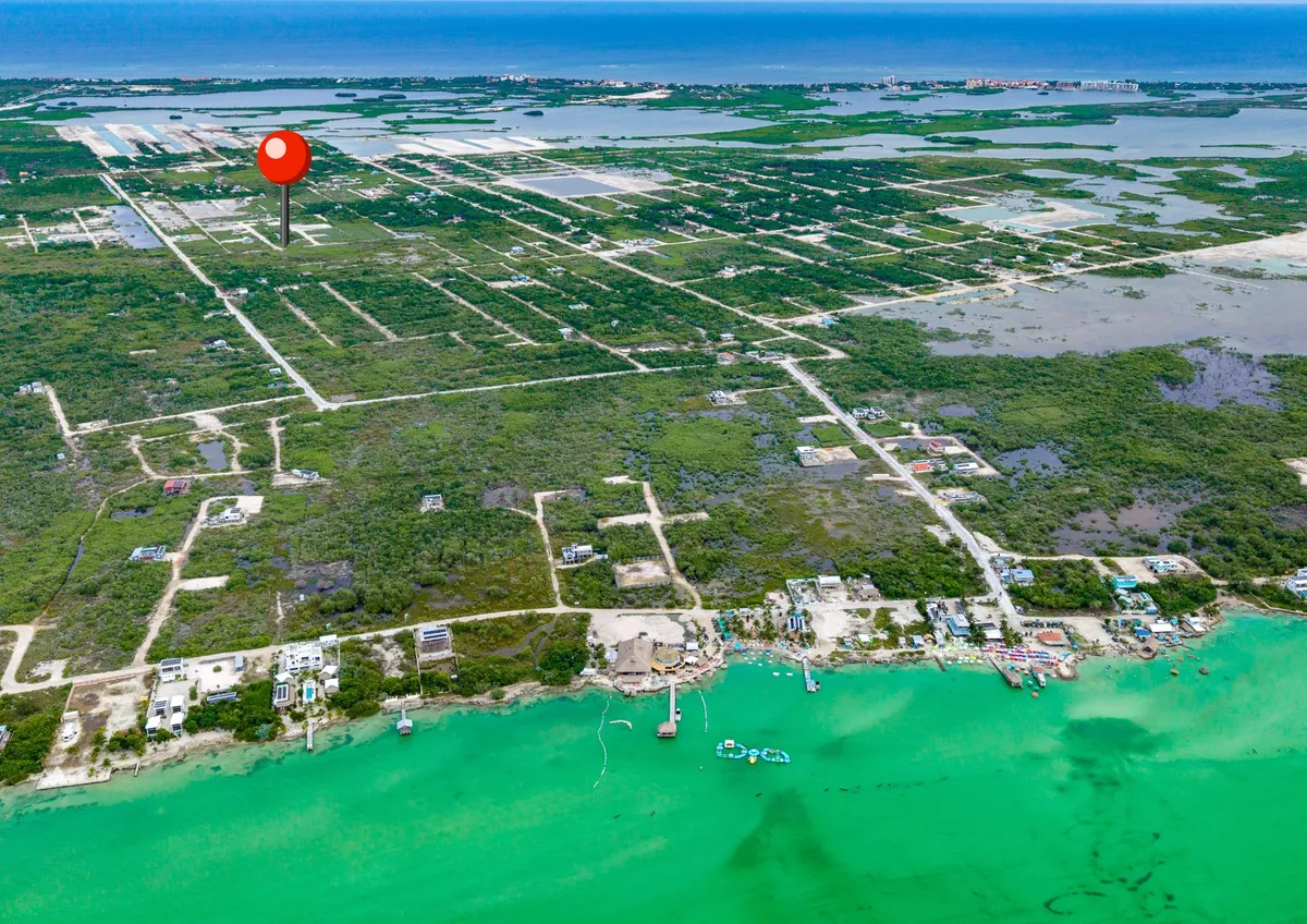 Aerial view of mangrove lots with gravel roads along green turquoise water