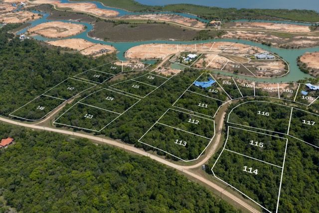 Aerial view of numbered lots outlined over wooded land beside a winding waterway