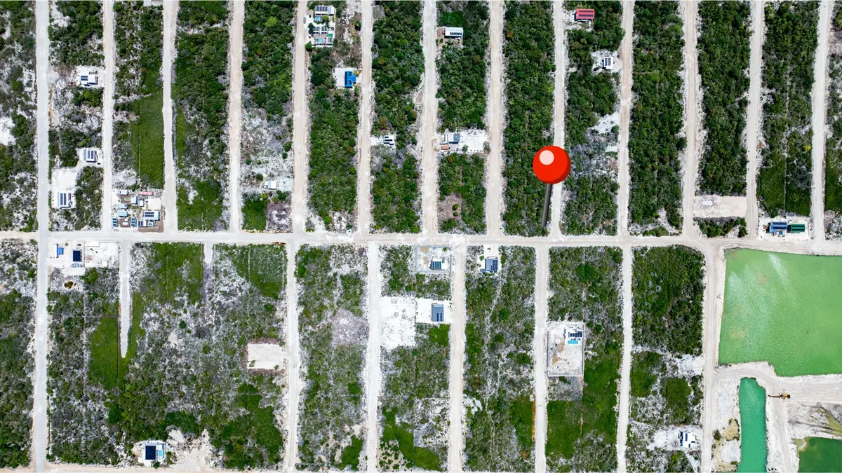Aerial view of cleared lots along dirt roads with scattered buildings