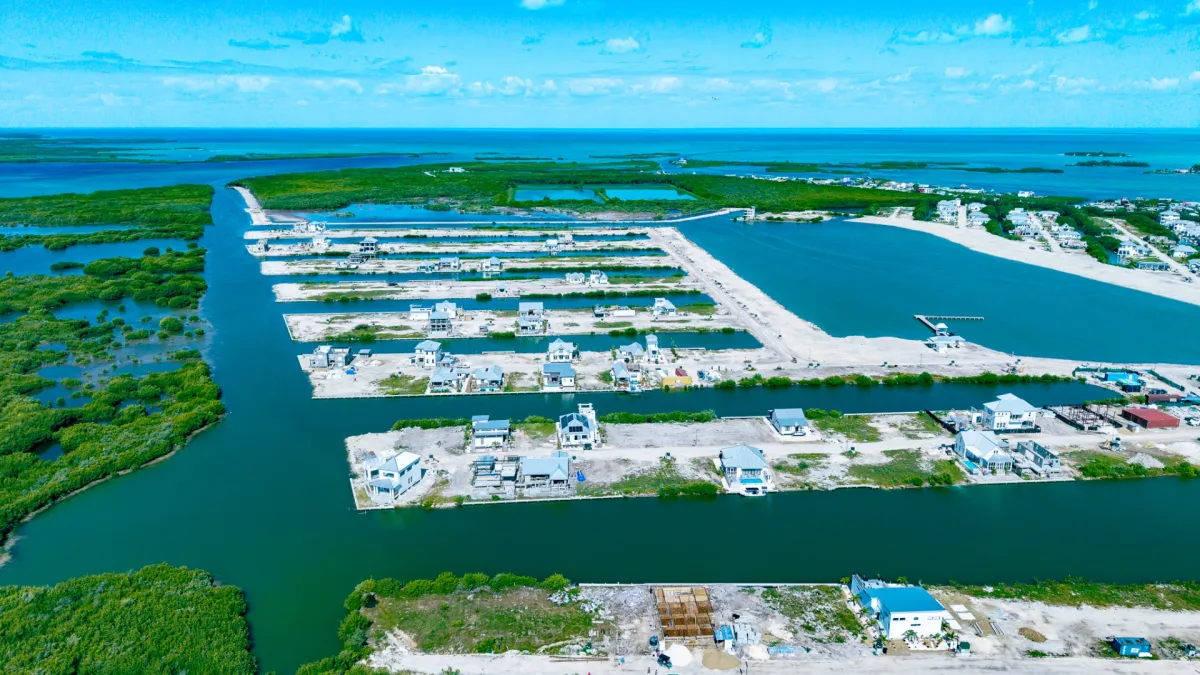Aerial view of canal-front lots with houses under construction beside water