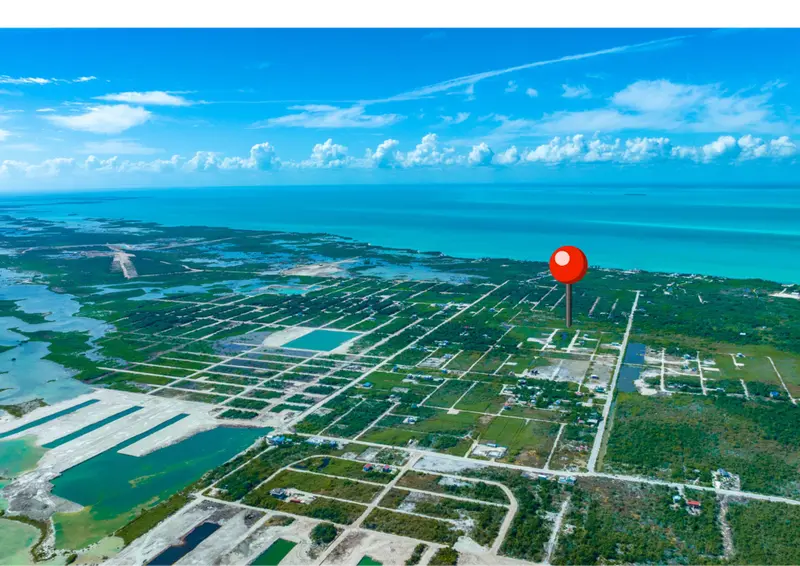Aerial view of gridded land parcels with scattered buildings along turquoise sea