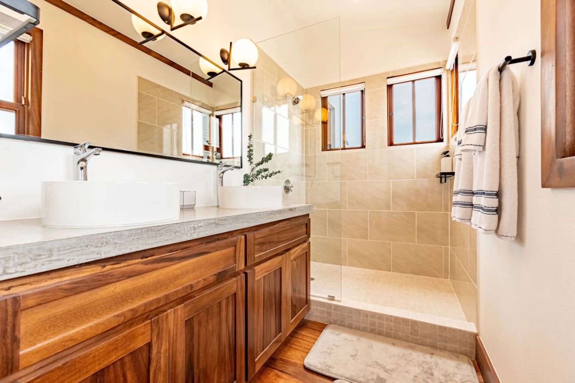 Bathroom with wood vanity, vessel sink and walk-in tiled shower