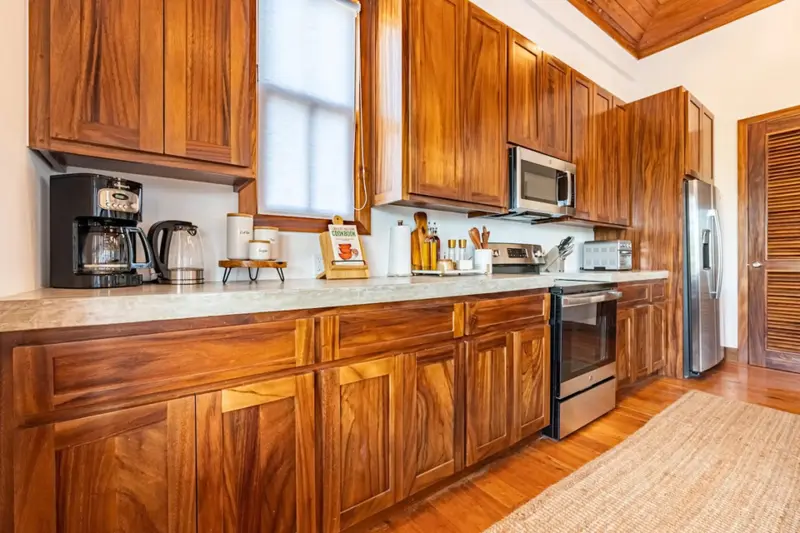 Kitchen with warm wood cabinets, pale countertop and stainless steel microwave