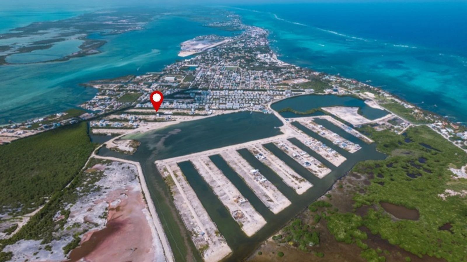 Aerial view of canal-lined residential lots with sea and town beyond