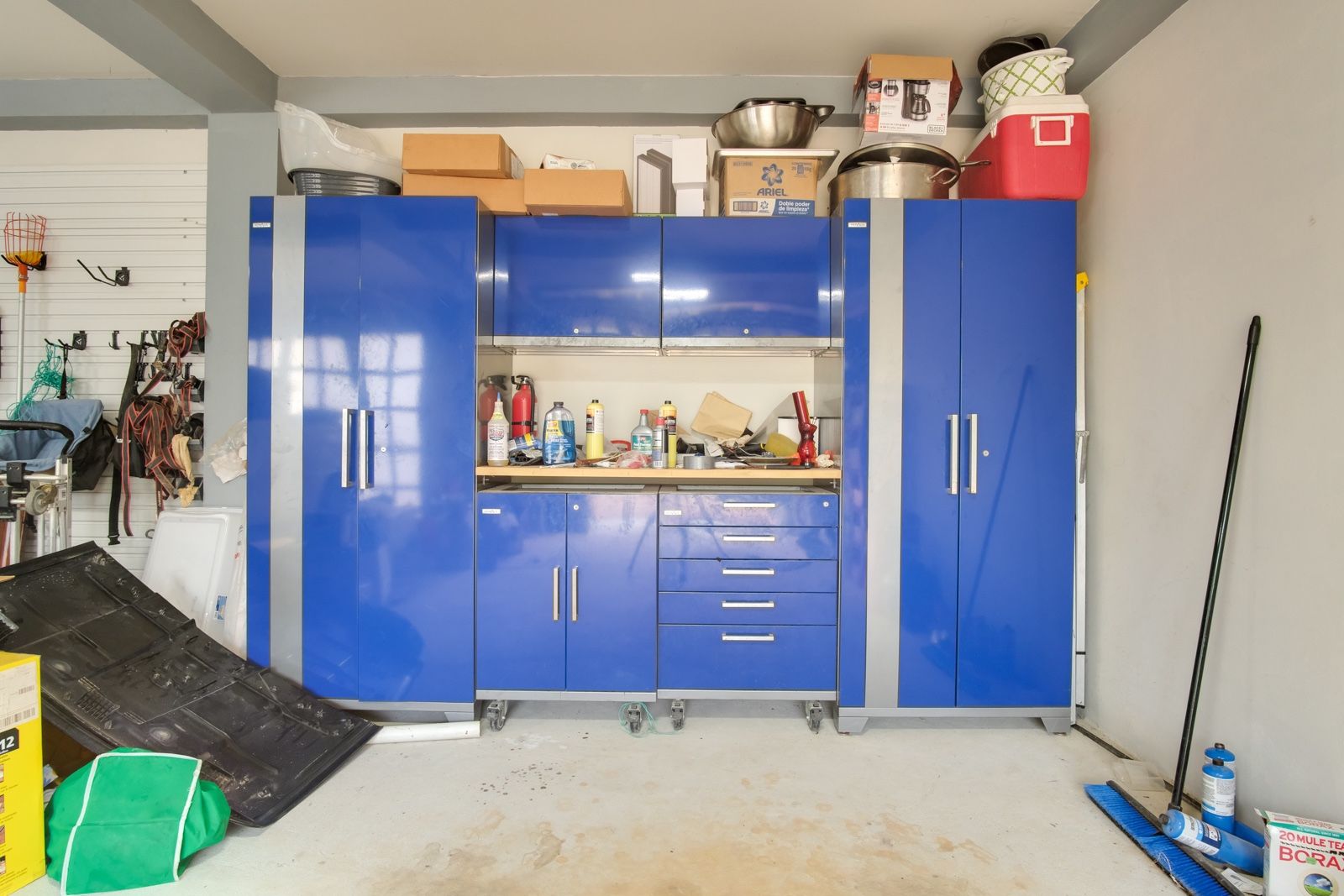 Garage with blue wall cabinets, drawers and a wooden work counter