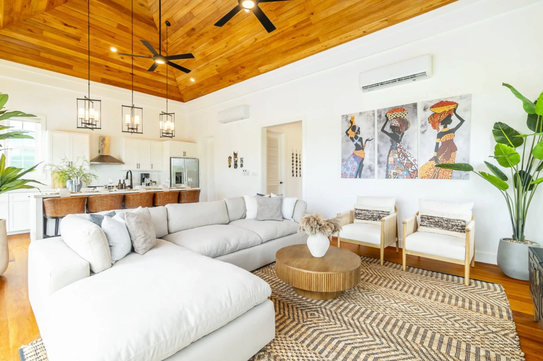 Living room with white sectional sofa, wood ceiling and round wooden coffee table