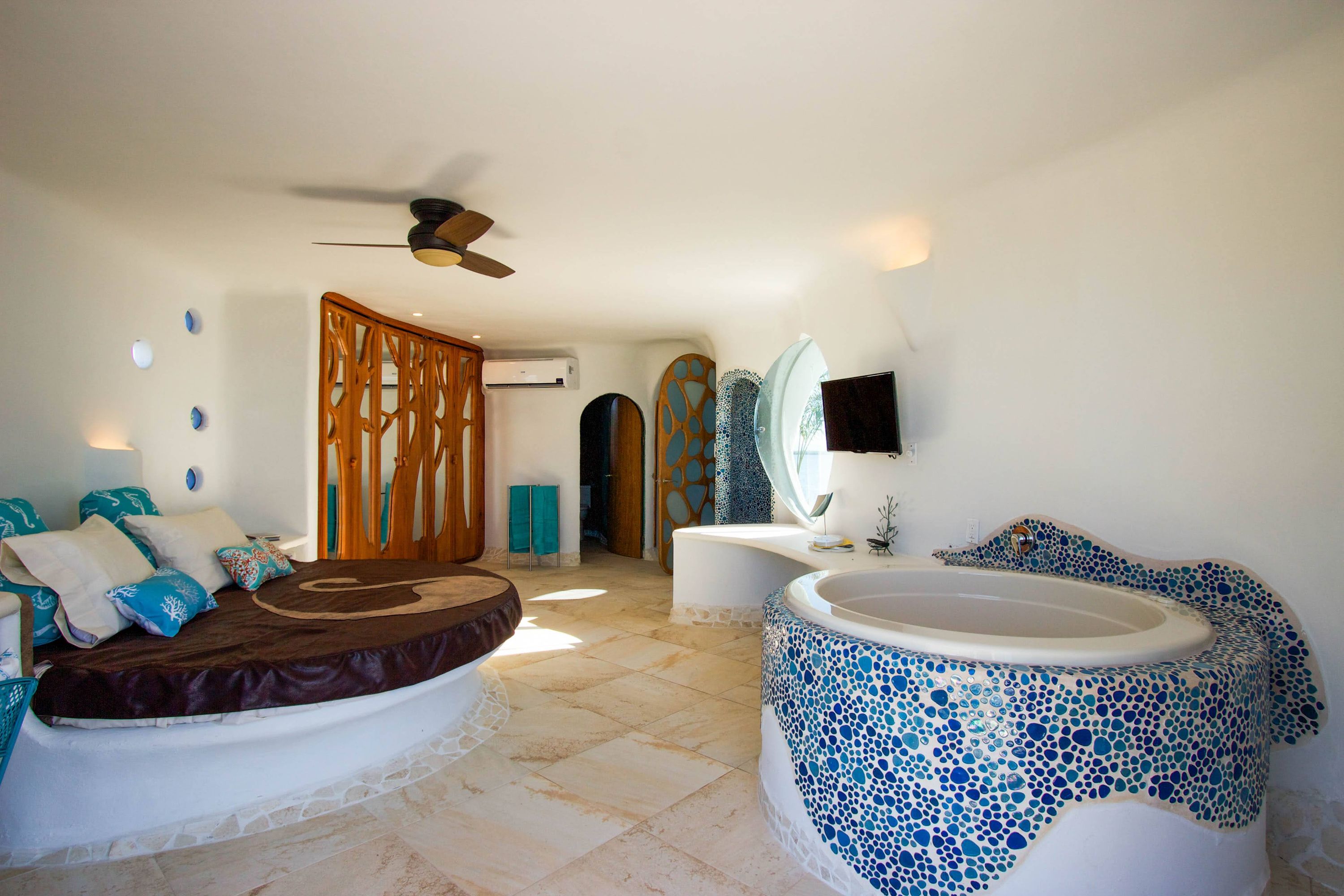 Bathroom with curved white tub and blue mosaic tile accents