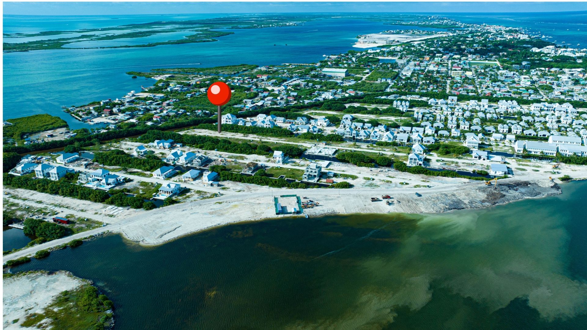 Aerial view of coastal lots with houses and water beyond
