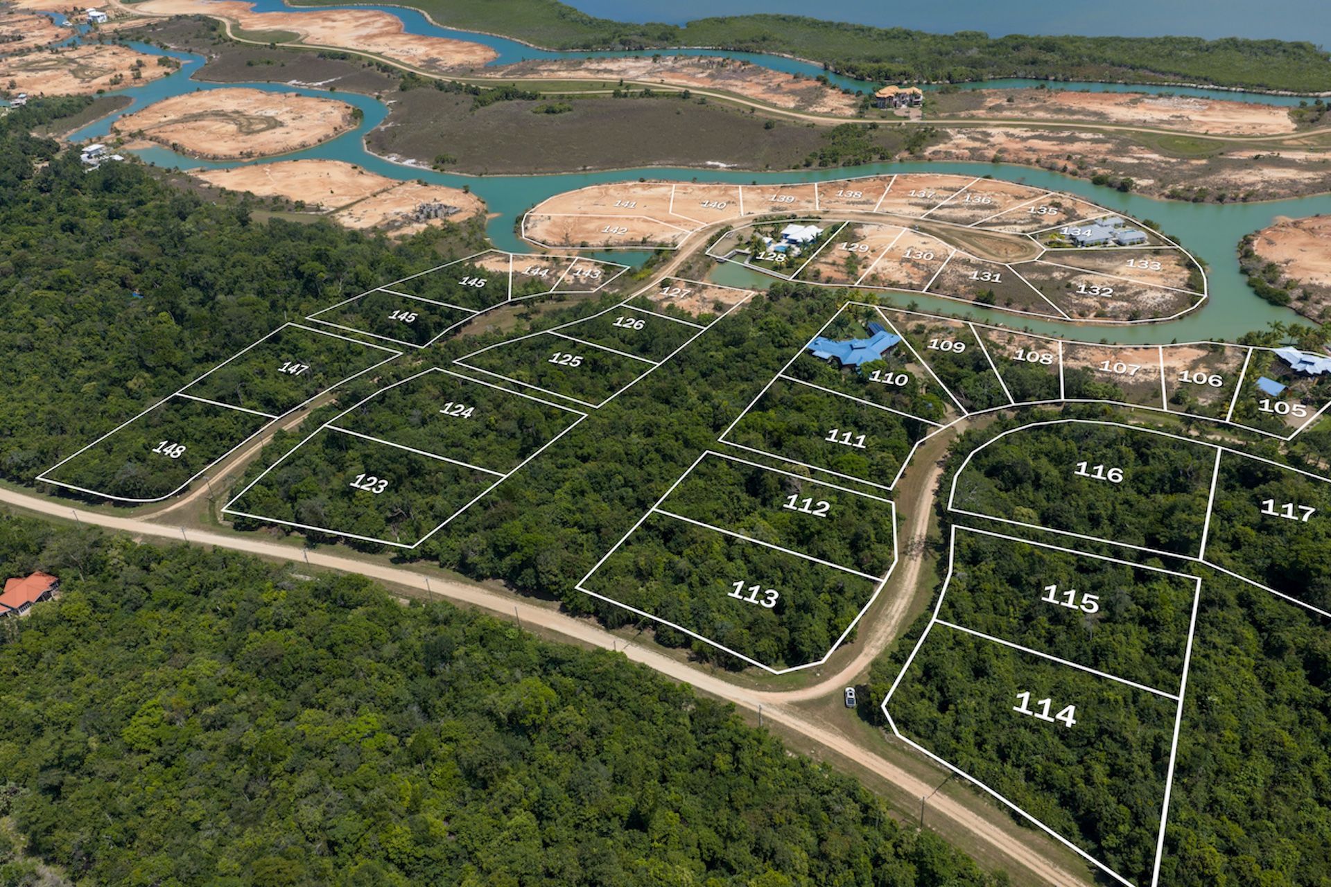 Aerial view of numbered land parcels outlined in white above forested lots