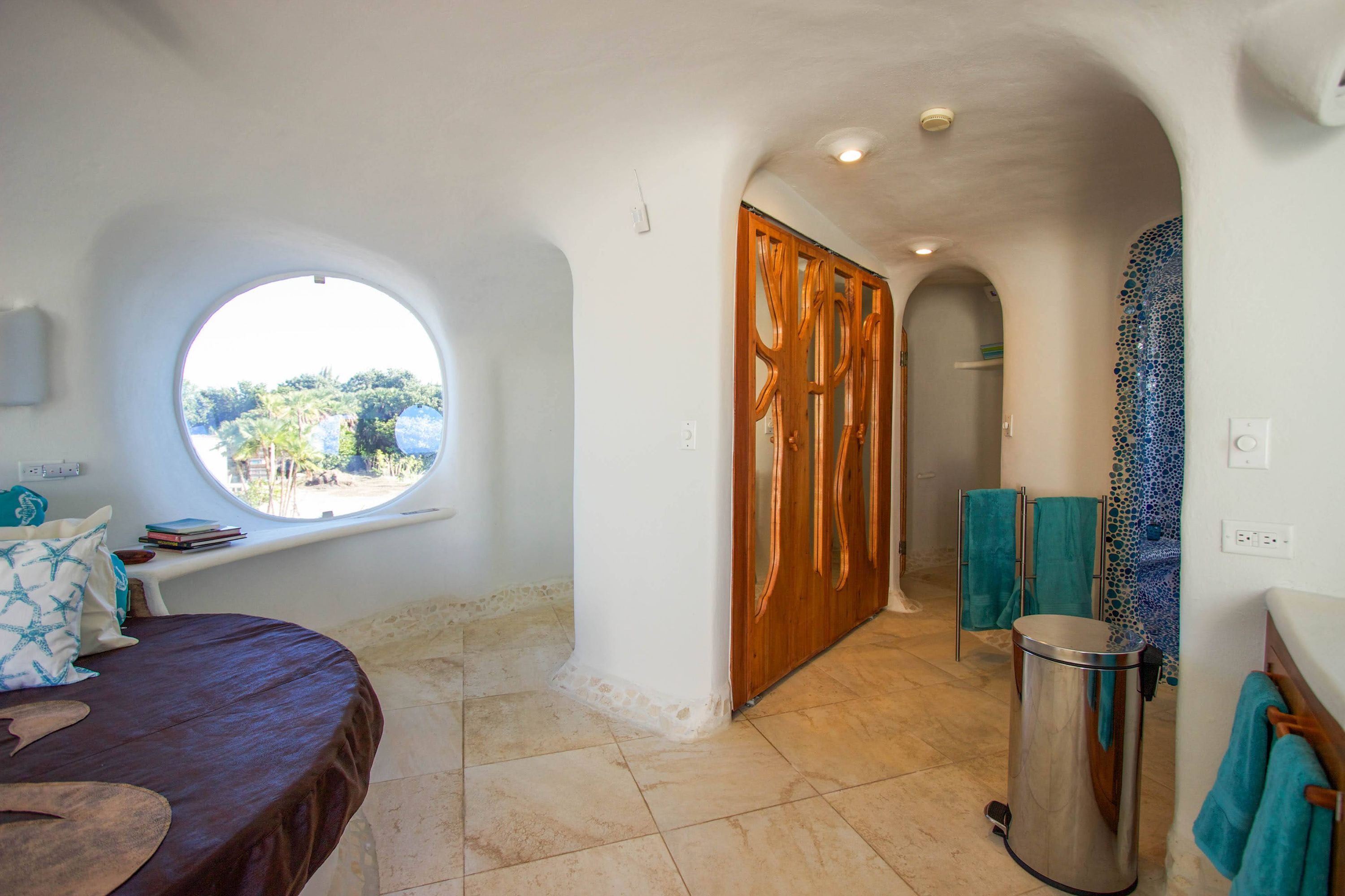 Interior hallway with curved white plaster wall and carved wooden door