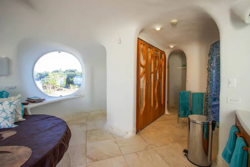 Interior hallway with curved white plaster wall and carved wooden door
