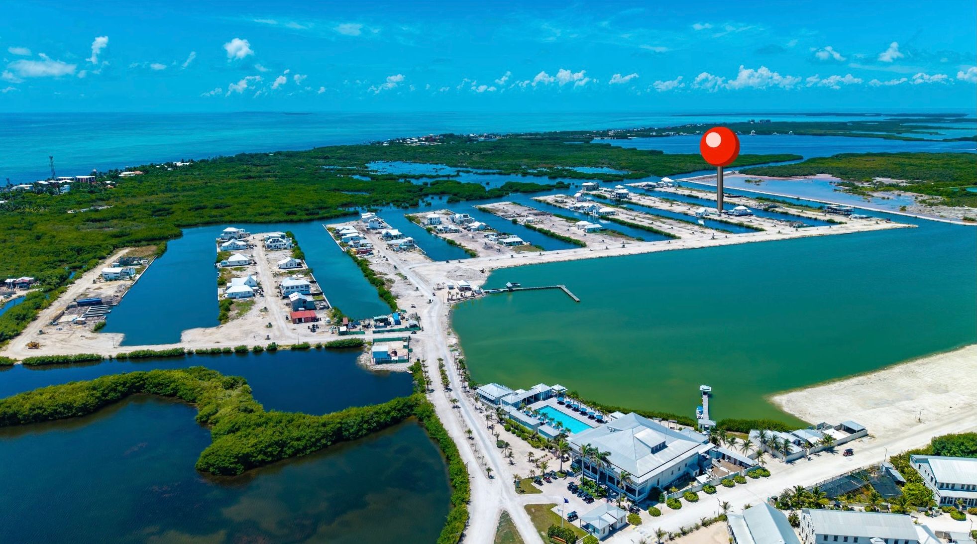 Aerial view of a waterfront development with canals, mangroves and a pool