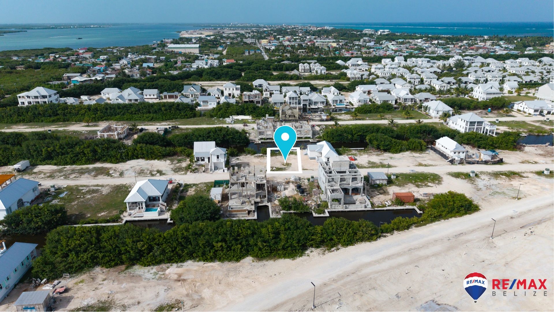 Aerial view of vacant lot outlined in white beside canal and nearby construction