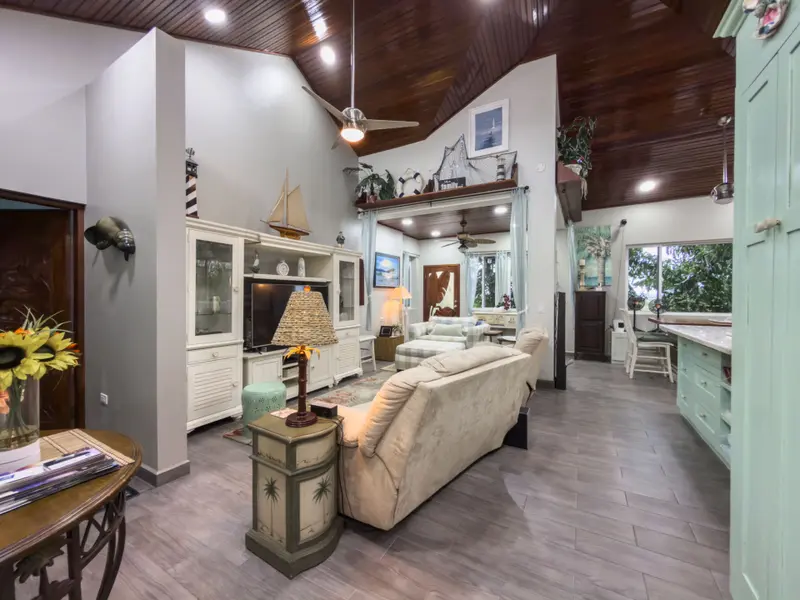 Living room with vaulted wood ceiling, beige sofa and nautical decor